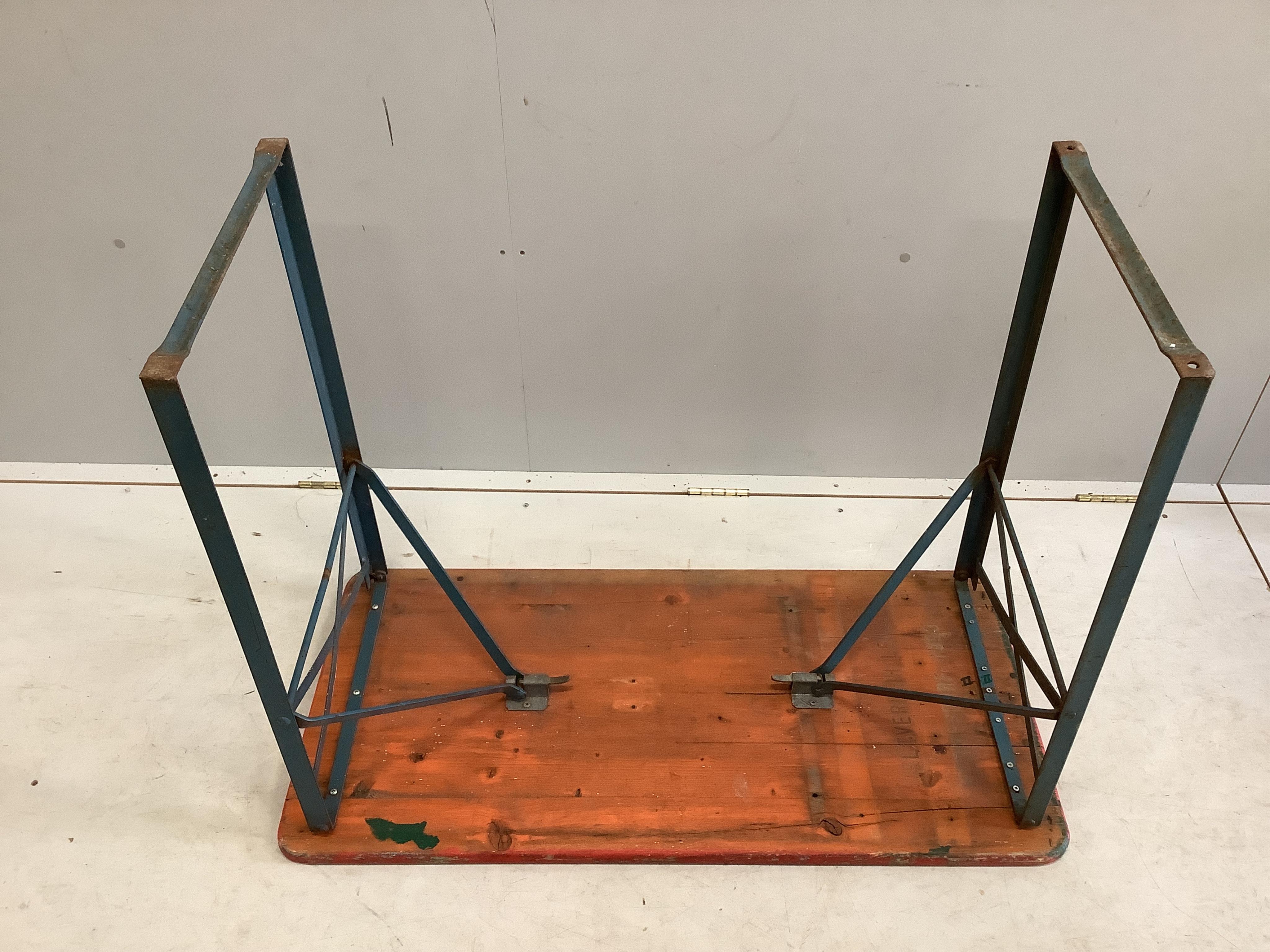 Two folding tables, width 103cm, depth 50cm, height 77cm, together with four red painted benches, with folding iron underframes. Condition - poor to fair